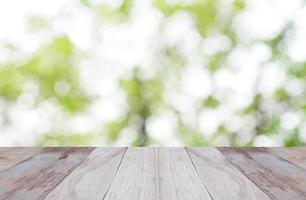 tavolo in legno superiore vuoto e natura sfocata con sfondo bokeh. foto