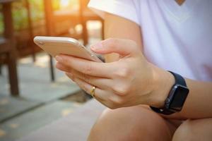 donna che utilizza lo smartphone mobile all'aperto sullo sfondo della natura foto