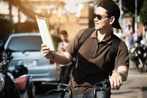 uomo turistico asiatico in una città che usa la bicicletta - concetto di viaggio urbano della via foto