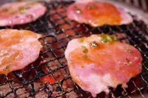 grigliata di maiale sui carboni ardenti. questo tipo di cibo è uno stile barbecue coreano o giapponese. foto