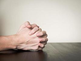 mani giunte insieme sul tavolo, concetto di preghiera foto