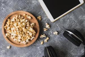 popcorn con tablet bianco e cuffie su sfondo grunge. foto