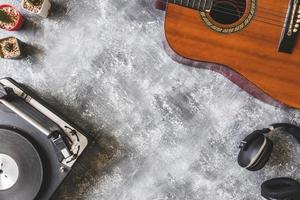 vista dall'alto del giradischi vintage con chitarra, cuffie e cactus su sfondo grunge, spazio libero per il testo foto