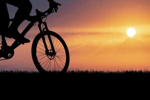 sagome di mountain bike e ciclisti la sera felici. concetto di viaggio e fitness. silhouette di ciclisti in tournée la sera concetto di cicloturismo foto