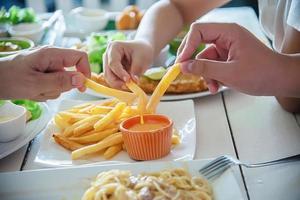 tempo in famiglia mangiare patatine fritte insieme - vita familiare con il concetto di cibo foto