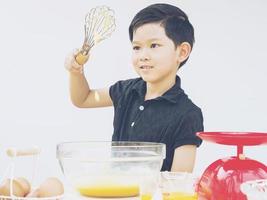 un ragazzo sta facendo la torta. la foto è focalizzata sui suoi occhi.