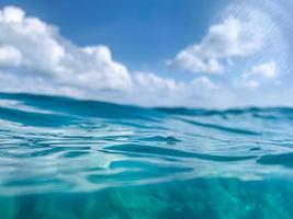 vista astratta sull'oceano. superficie dell'acqua blu del mare o dell'oceano e sott'acqua con cielo soleggiato e nuvoloso foto