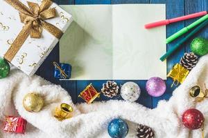 vista dall'alto della confezione regalo con decorazioni natalizie e carta sullo sfondo del tavolo in legno. foto