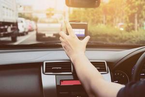 uomo che usa il navigatore mentre guida un'auto in una strada a traffico urbano foto