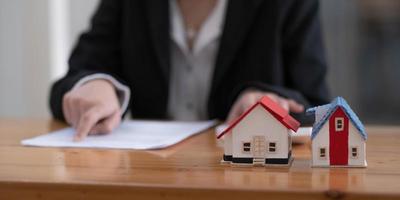 donna d'affari presente contatto del contratto di assicurazione casa per l'acquisto di una casa con un agente immobiliare. foto