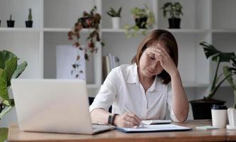 donna anziana che utilizza un computer portatile e seria sul lavoro foto