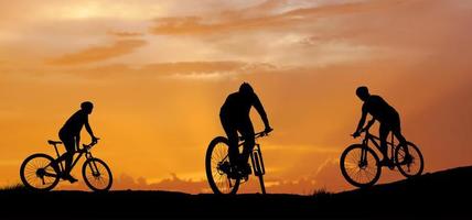 sagoma di un mountain biker godendo in discesa durante il tramonto. concetto di mountain bike. gara di mountain bike - ciclista silhouette sullo sfondo. foto