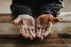 primo piano di mani rugose maschili, il vecchio indossa sul legno. tono vintage foto