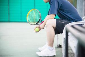 giocatore di tennis triste seduto in tribunale dopo aver perso una partita - persone nel concetto di gioco di tennis sportivo foto