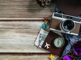 fotocamera e passaporto su tavolo di legno per il concetto di viaggio. foto