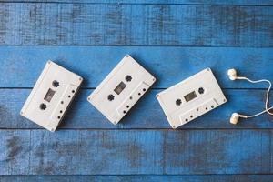 vista dall'alto del nastro audio con auricolari su sfondo blu tavolo in legno foto