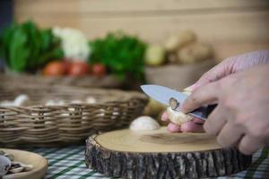 la signora cucina la verdura fresca dei funghi champignon in cucina - persone con il concetto di cottura delle verdure foto