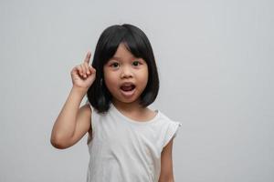 ritratto di bambino asiatico di 5 anni e raccogliere i capelli e mettere le mani sul mento e fare una posa pensante su sfondo bianco isolato, lei è felicità, splendore in gioventù, concetto di educazione foto