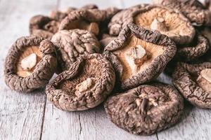 primo piano di funghi shiitake secchi sul tavolo di legno. messa a fuoco selettiva foto