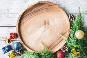 vista dall'alto del piatto di legno con decorazioni natalizie su sfondo tavolo in legno foto