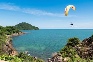 bellissimo paesaggio marino con parapendio che vola nel cielo blu. foto