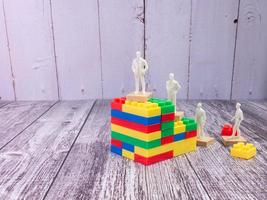 figura aziendale e blocco puzzle multicolore per il concetto di strategia foto