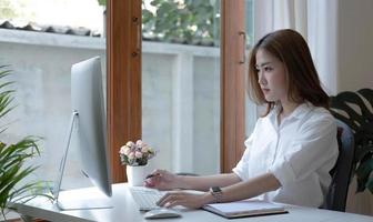 immagine di una donna asiatica stanca e ripensante per aver lavorato con un tablet in ufficio. foto