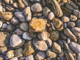 pietre sulla spiaggia, ciottoli come sfondo astratto foto