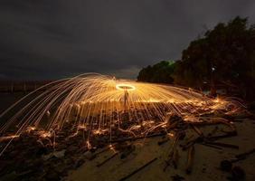 giocando con le fiamme tenendo un fuoco per provocare fiocchi foto