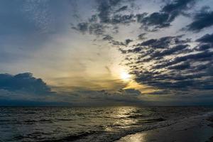 il cielo serale ha nuvole piene di cielo, la luce del sole riflette l'acqua di mare, la superficie del mare foto