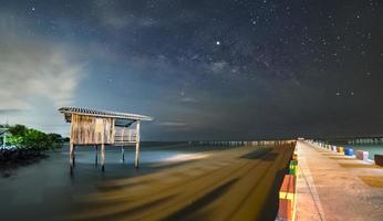 vecchia casa di legno, non più abitata nel mare, non più in alto la casa presa con la via lattea come sfondo foto