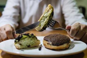 ragazzo che taglia le ciambelle da mangiare foto