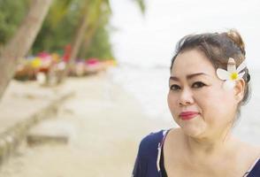 signora asiatica che si rilassa sulla spiaggia durante la sua vacanza foto