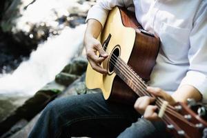 l'uomo suona l'ukulele nuovo alla cascata - persone e strumenti musicali stile di vita nel concetto di natura foto