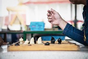 la gente locale tailandese gioca a scacchi tailandesi tradizionali antichi nell'area pubblica - gente locale di stile di vita lenta con il concetto di gioco di scacchiera foto