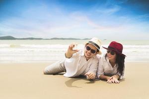 vacanza delle coppie che scatta foto sulla spiaggia di sabbia, tailandia