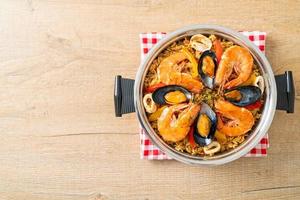 paella di mare con gamberi, vongole, cozze su riso allo zafferano foto