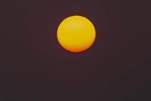 il sole della sera o del mattino può essere visto ad occhio nudo. il sole è rosso a causa della polvere e dell'atmosfera. foto