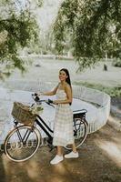 giovane donna con bici elettrica e fiori nel cestino foto