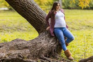 giovane donna incinta nel parco d'autunno foto