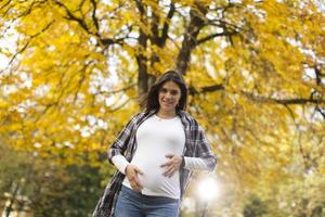 donna incinta nel parco autunnale foto