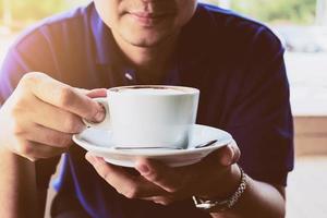 uomo d'affari che beve caffè in una caffetteria foto