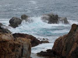 mare agitato, onde che si infrangono sugli scogli foto