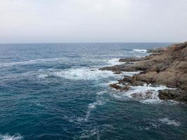 mare agitato, onde che si infrangono sugli scogli foto