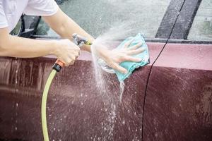 l'uomo lava l'auto usando lo shampoo - concetto di cura dell'auto per la vita quotidiana foto