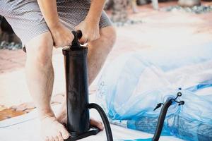 le persone stanno pompando una grande piscina di giocattoli in gomma - lo stile di vita familiare gioca a casa foto