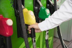 uomo che mette benzina nella sua auto in una stazione di servizio della pompa foto