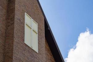 la croce nel muro della chiesa con cielo azzurro e nuvole bianche sullo sfondo foto