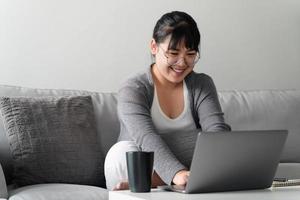 donna che usa il laptop che lavora a casa in ufficio o sul posto di lavoro. foto