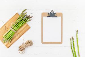 asparagi verdi freschi con mockup di appunti di carta foto